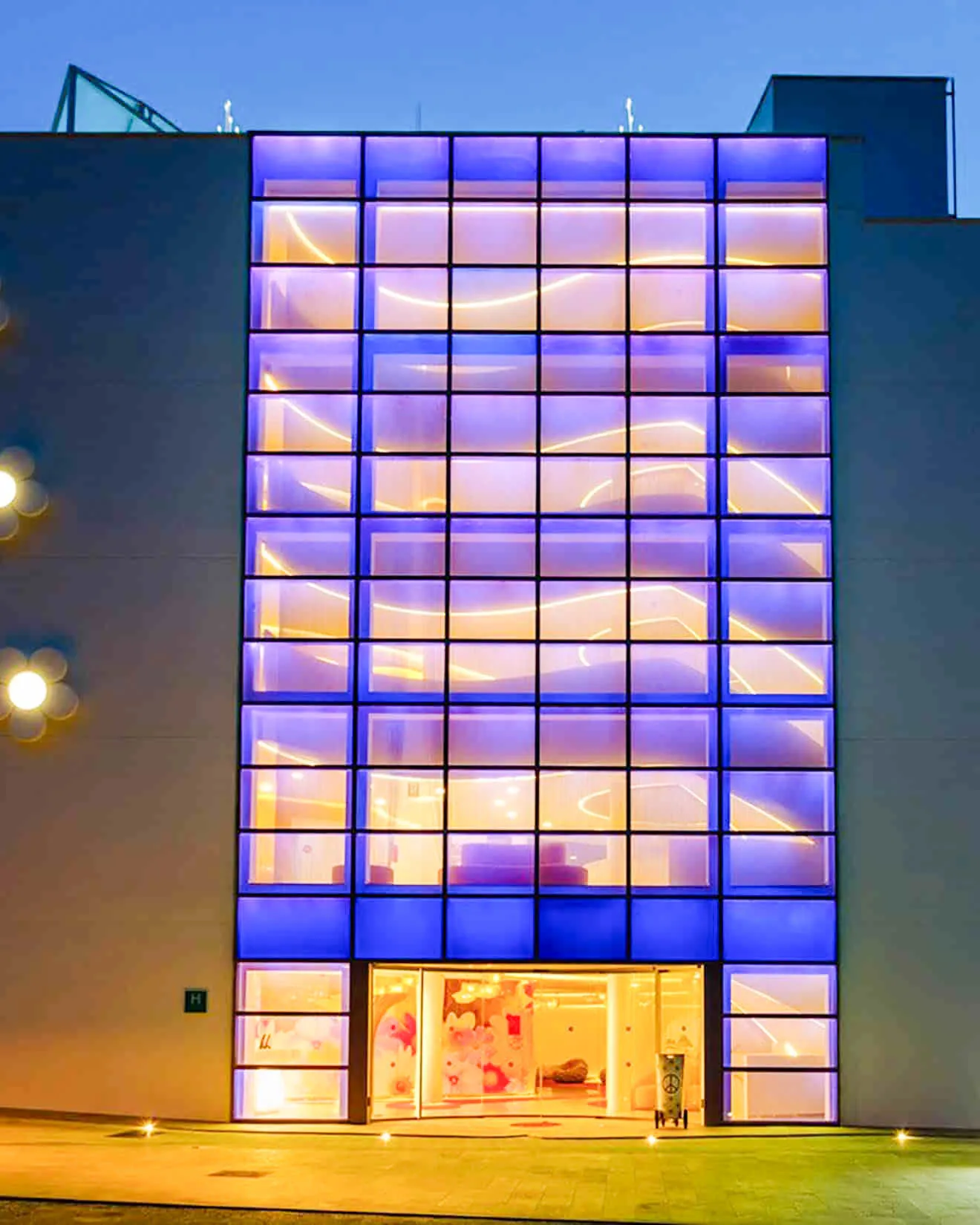 Fachada iluminada del Five Flowers Hotel & Spa Formentera con diseño moderno y luces vibrantes